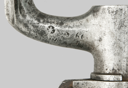 Close-up view of inspection marks on elbow. Sunburst and Raised letter L.